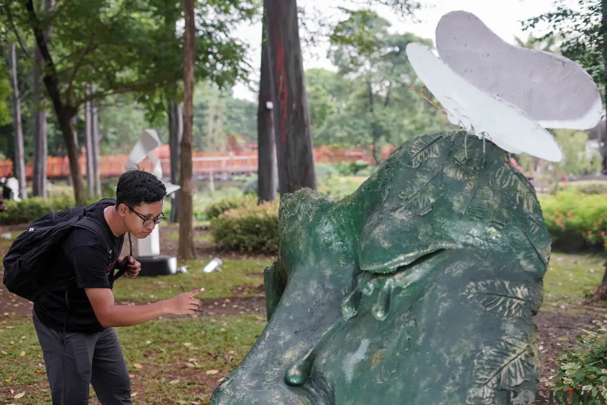 Pengunjung mengamati patung dalam pameran Jakarta Artmosphere 2025 di Tebet Eco Park, Jakarta, Senin, 20 Oktober 2025. (Sumber: Poskota/Bilal Nugraha Ginanjar)