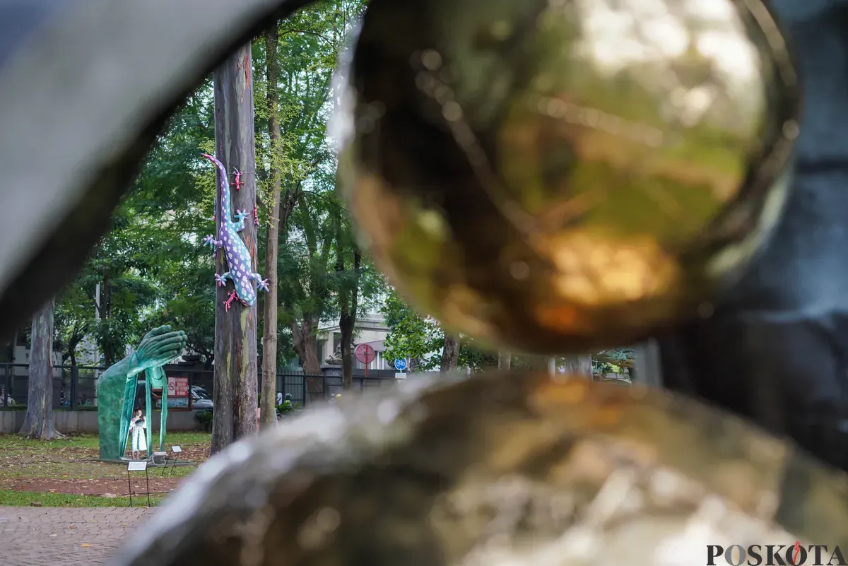 Pengunjung mengamati patung dalam pameran Jakarta Artmosphere 2025 di Tebet Eco Park, Jakarta, Senin, 20 Oktober 2025. (Sumber: Poskota/Bilal Nugraha Ginanjar)