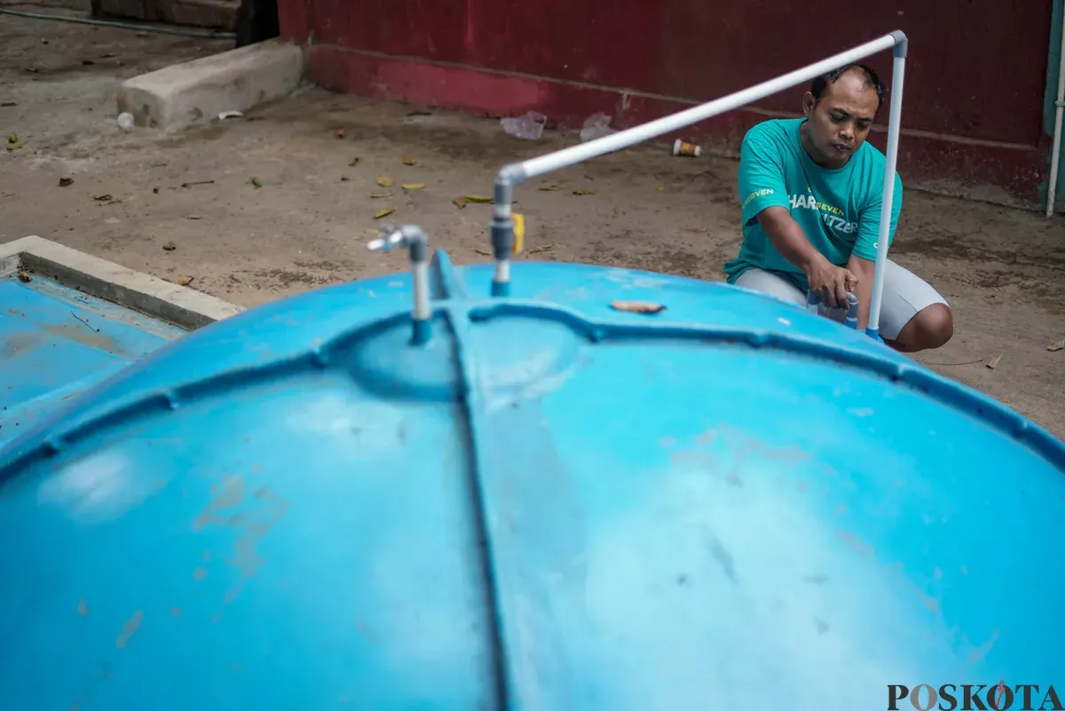 Warga memeriksa saluran pada tangki septik komunal biogas di Rusun Bidara Cina, Jatinegara, Jakarta Timur, Senin, 20 Oktober 2025. (Sumber: Poskota/Bilal Nugraha Ginanjar)