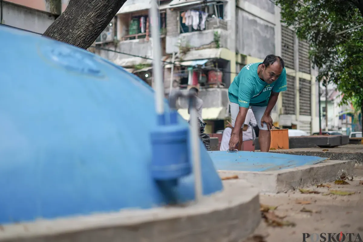 Warga memeriksa saluran pada tangki septik komunal biogas di Rusun Bidara Cina, Jatinegara, Jakarta Timur, Senin, 20 Oktober 2025. (Sumber: Poskota/Bilal Nugraha Ginanjar)