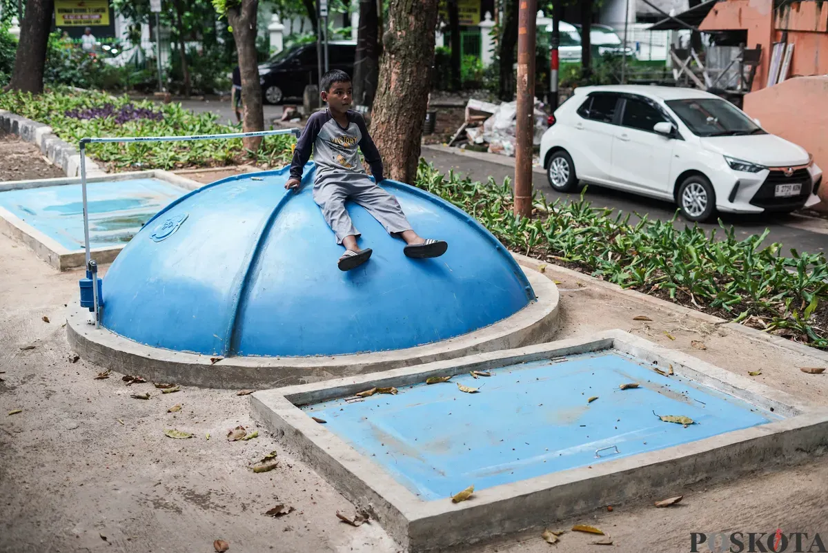 Warga memeriksa saluran pada tangki septik komunal biogas di Rusun Bidara Cina, Jatinegara, Jakarta Timur, Senin, 20 Oktober 2025. (Sumber: Poskota/Bilal Nugraha Ginanjar)