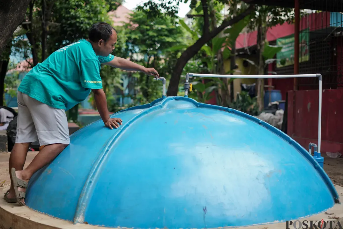 Warga memeriksa saluran pada tangki septik komunal biogas di Rusun Bidara Cina, Jatinegara, Jakarta Timur, Senin, 20 Oktober 2025. (Sumber: Poskota/Bilal Nugraha Ginanjar)