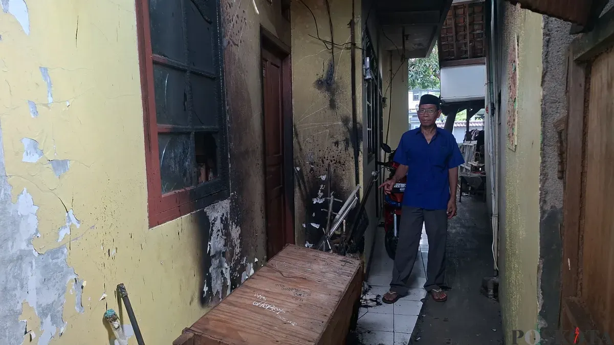Pemilik kontrakan, H. Mahrub, 63 tahun, menunjukkan kondisi rumah kontrakan di Ciganjur, Jakarta Selatan, yang hangus terbakar setelah disiram bensin oleh mantan pacar penghuni, Jumat, 17 Oktober 2025, subuh. (Sumber: Poskota/Angga Pahlevi)