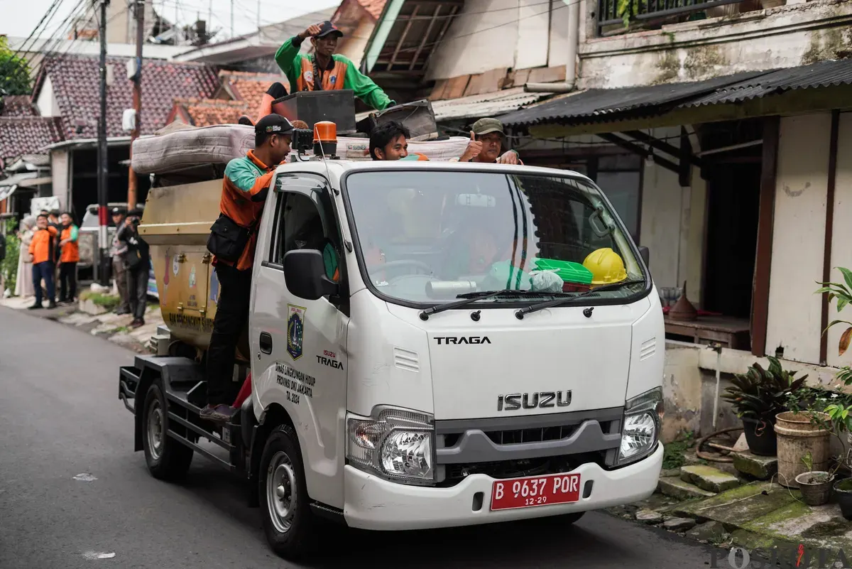 Petugas Dinas Lingkungan Hidup Kota Jakarta Timur mengangkut kayu lemari bekas milik warga menggunakan mobil truk di kawasan Cijantung, Pasar Rebo, Jakarta, Selasa, 21 Oktober 2025. (Sumber: Poskota/Bilal Nugraha Ginanjar)