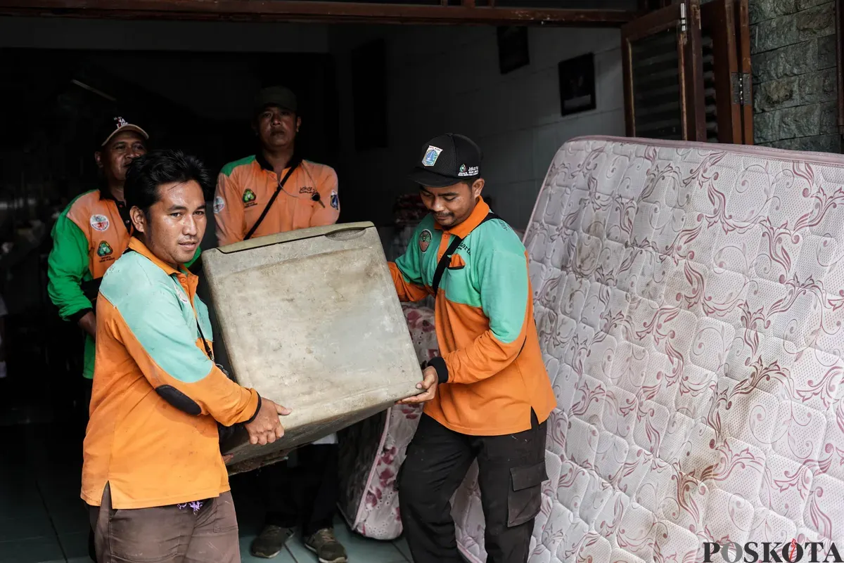 Petugas Dinas Lingkungan Hidup Kota Jakarta Timur mengangkut lemari bekas milik warga menggunakan mobil truk di kawasan Cijantung, Pasar Rebo, Jakarta, Selasa, 21 Oktober 2025. (Sumber: Poskota/Bilal Nugraha Ginanjar)