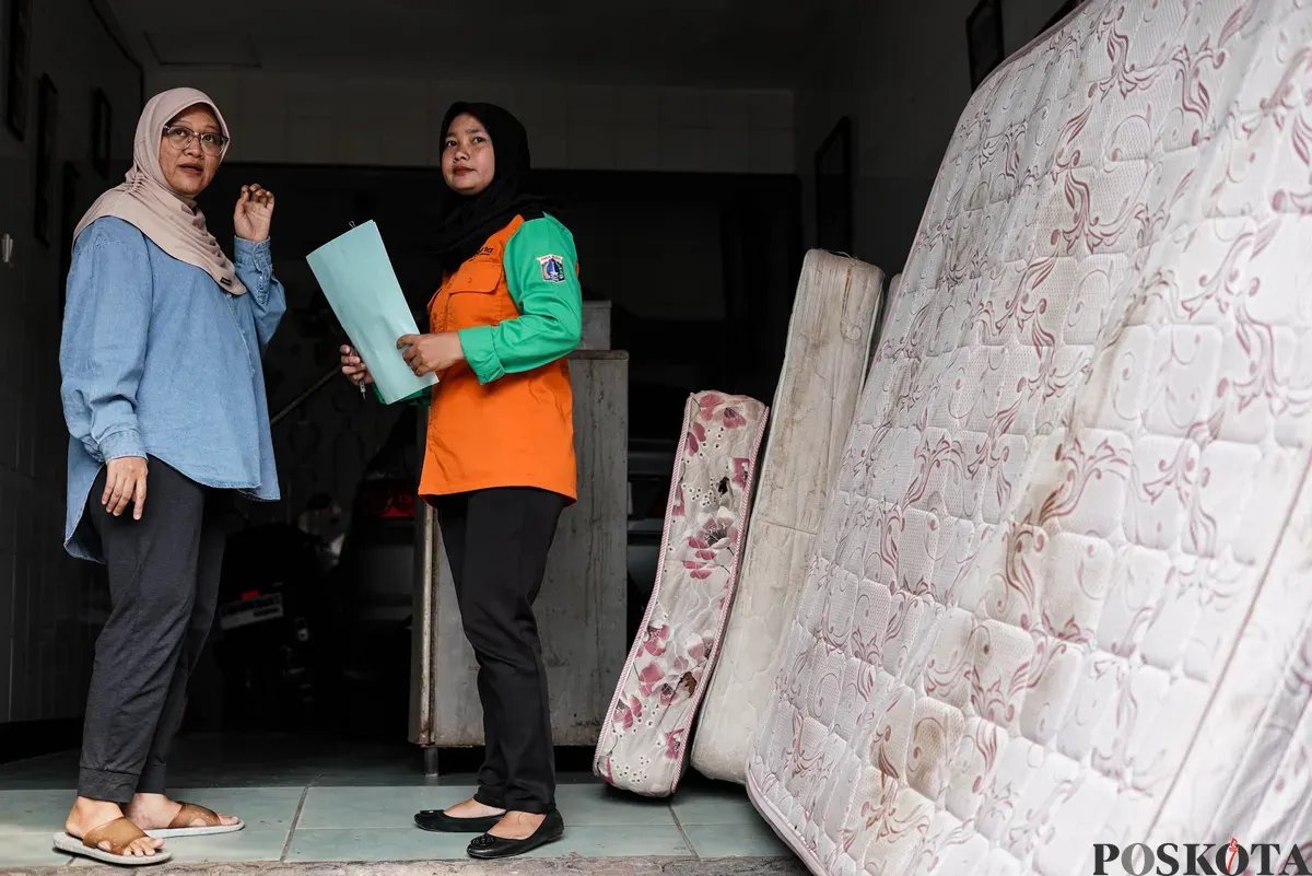 Petugas Dinas Lingkungan Hidup Kota Jakarta Timur mendata barang bekas milik warga menggunakan mobil truk di kawasan Cijantung, Pasar Rebo, Jakarta, Selasa, 21 Oktober 2025. (Sumber: Poskota/Bilal Nugraha Ginanjar)