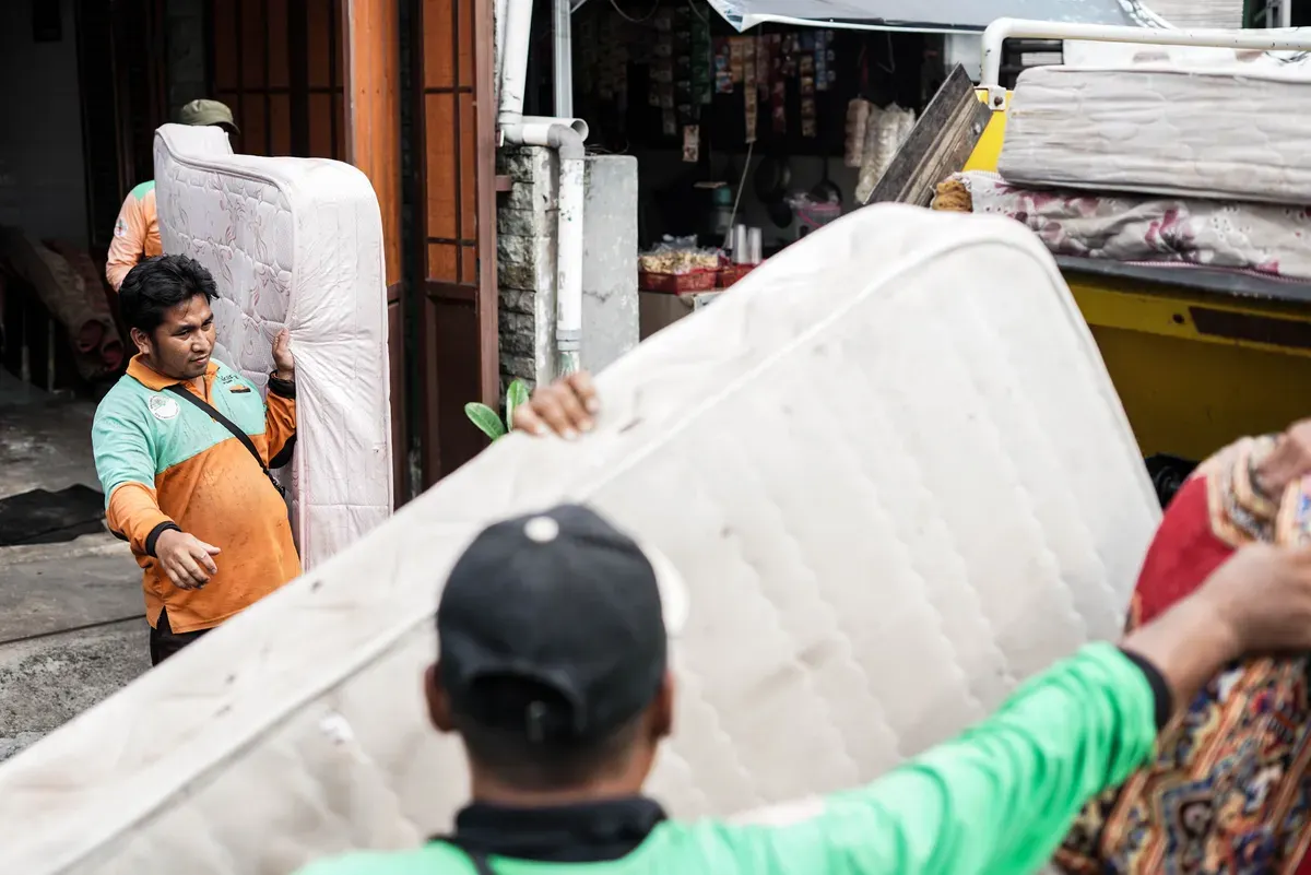 Petugas Dinas Lingkungan Hidup Kota Jakarta Timur mengangkut kasur bekas milik warga menggunakan mobil truk di kawasan Cijantung, Pasar Rebo, Jakarta, Selasa, 21 Oktober 2025. (Sumber: Poskota/Bilal Nugraha Ginanjar)