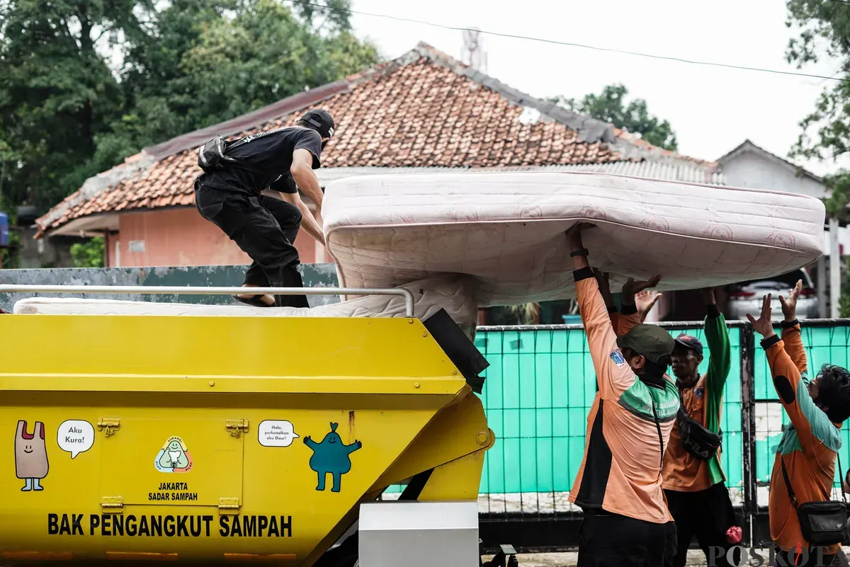 Petugas Dinas Lingkungan Hidup Kota Jakarta Timur mengangkut kasur bekas milik warga menggunakan mobil truk di kawasan Cijantung, Pasar Rebo, Jakarta, Selasa, 21 Oktober 2025. (Sumber: Poskota/Bilal Nugraha Ginanjar)