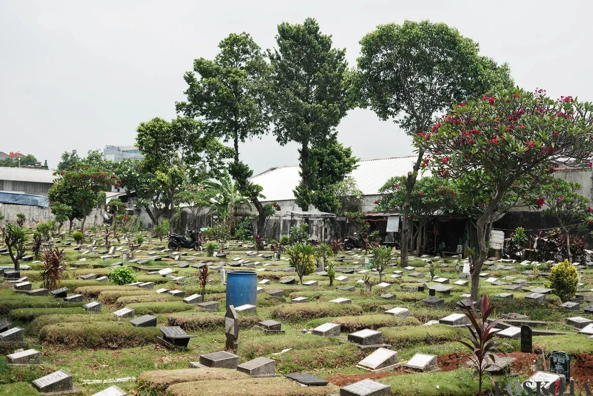 Petugas Suku Dinas Pertamanan dan Hutan Jakarta Selatan membersihkan salah satu makam di Tempat Pemakaman Umum (TPU) Grogol Selatan, Jakarta, Selasa, 21 Oktober 2025. (Sumber: Poskota/Bilal Nugraha Ginanjar)