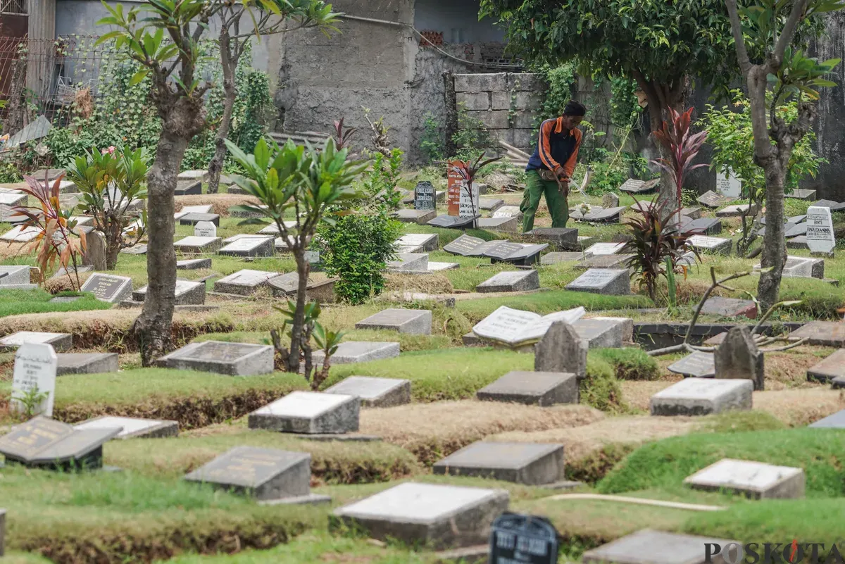 Petugas Suku Dinas Pertamanan dan Hutan Jakarta Selatan membersihkan salah satu makam di Tempat Pemakaman Umum (TPU) Grogol Selatan, Jakarta, Selasa, 21 Oktober 2025. (Sumber: Poskota/Bilal Nugraha Ginanjar)