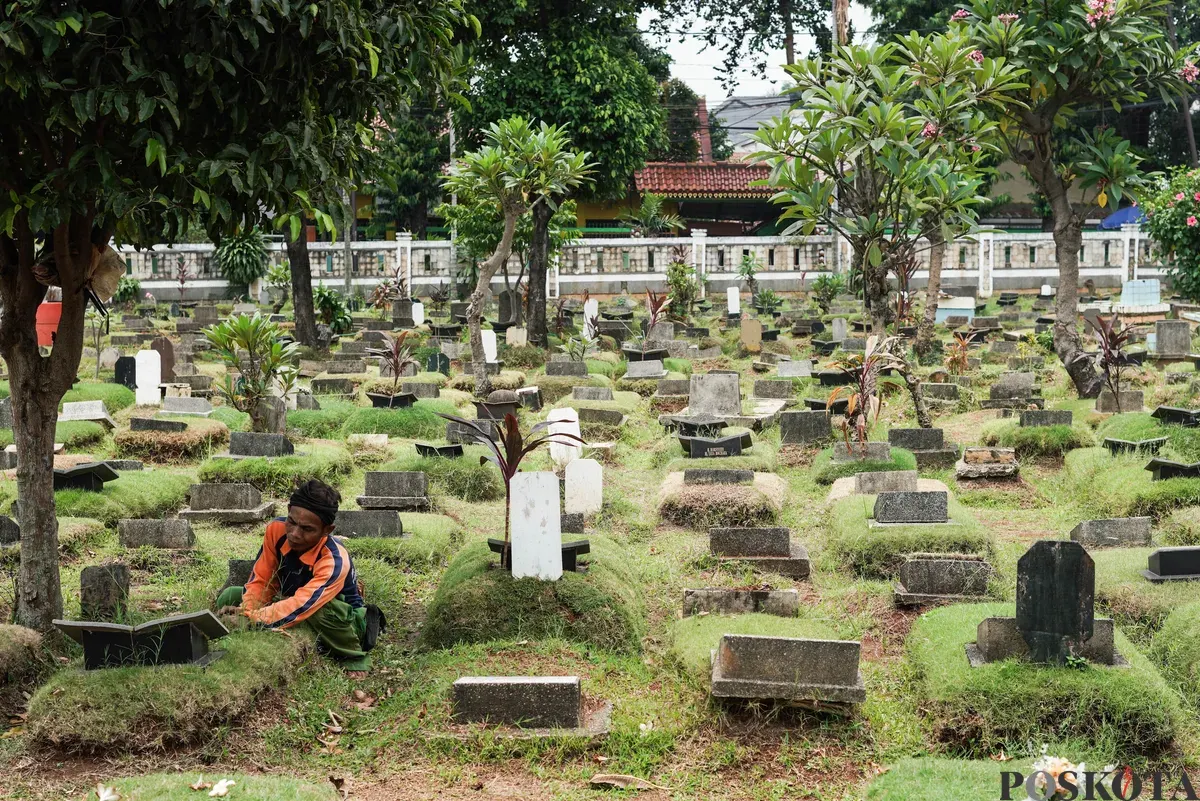 Petugas Suku Dinas Pertamanan dan Hutan Jakarta Selatan membersihkan salah satu makam di Tempat Pemakaman Umum (TPU) Grogol Selatan, Jakarta, Selasa, 21 Oktober 2025. (Sumber: Poskota/Bilal Nugraha Ginanjar)