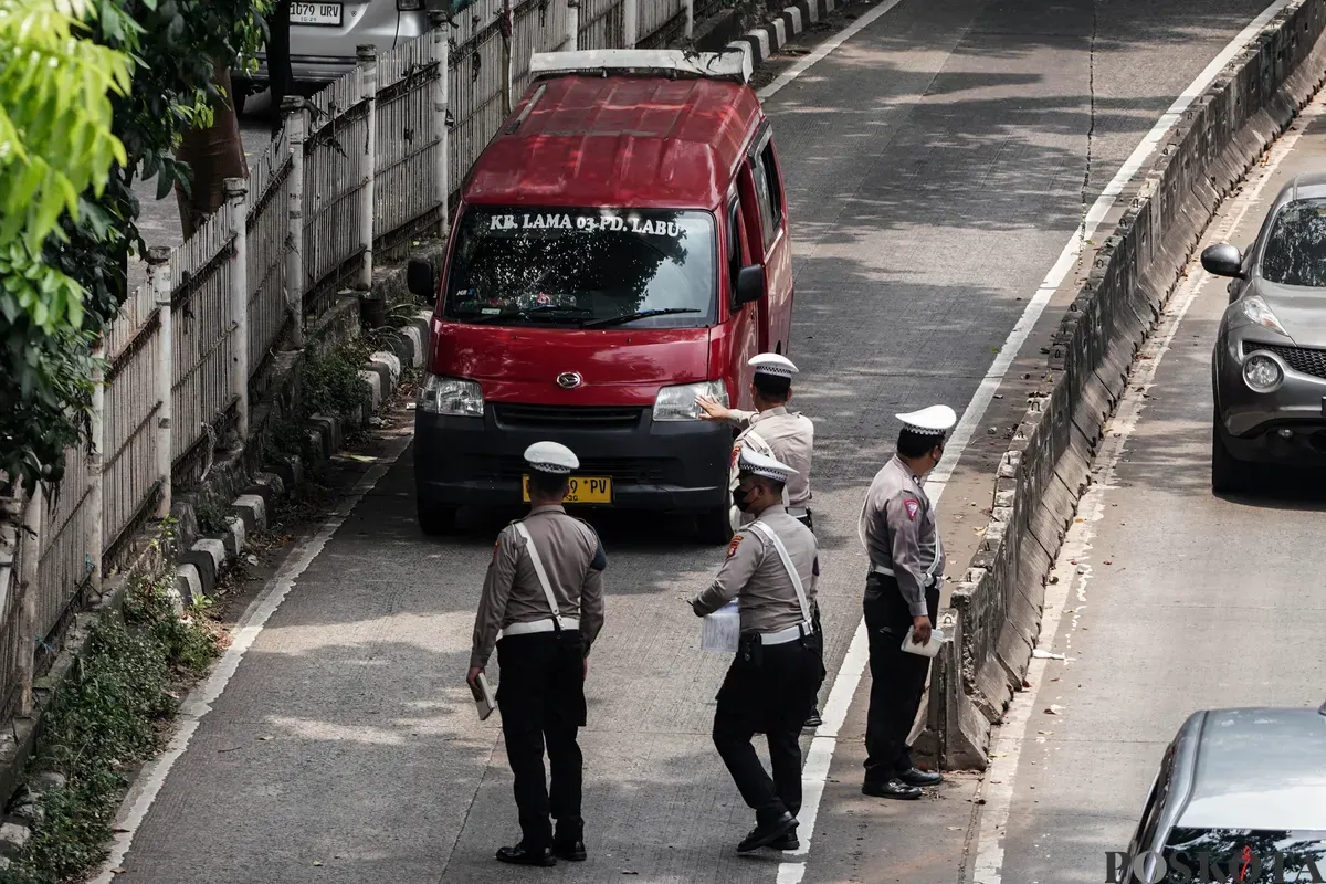 Sejumlah petugas kepolisian melakukan tilang kepada pengendara yang memasuki jalur Transjakarta di Jalan Sultan iskandar Muda, Jakarta Selatan, Selasa, 21 Oktober 2025. (Sumber: Poskota/Bilal Nugraha Ginanjar)