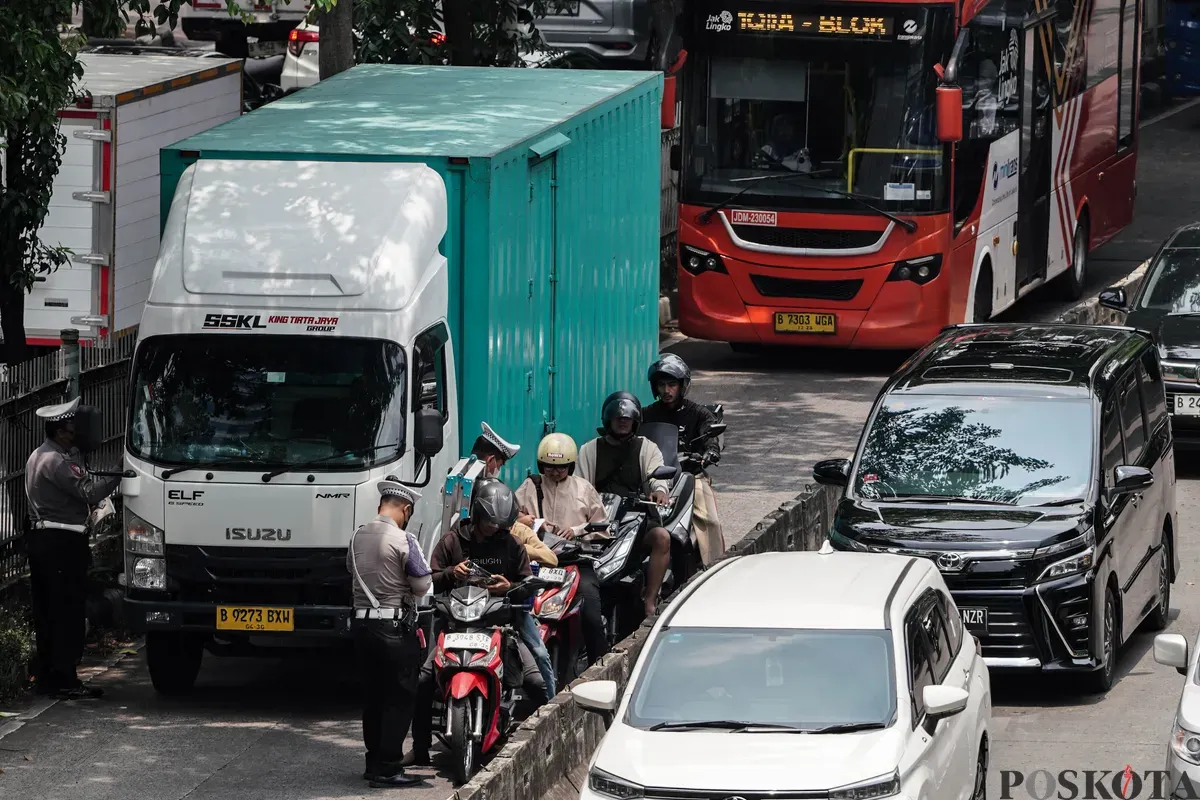 Sejumlah petugas kepolisian melakukan tilang kepada pengendara yang memasuki jalur Transjakarta di Jalan Sultan iskandar Muda, Jakarta Selatan, Selasa, 21 Oktober 2025. (Sumber: Poskota/Bilal Nugraha Ginanjar)