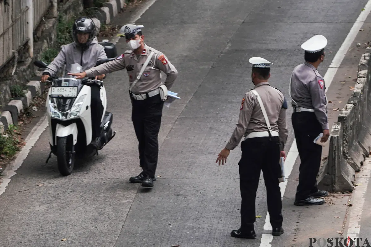 Sejumlah petugas kepolisian melakukan tilang kepada pengendara yang memasuki jalur Transjakarta di Jalan Sultan iskandar Muda, Jakarta Selatan, Selasa, 21 Oktober 2025. (Sumber: Poskota/Bilal Nugraha Ginanjar)