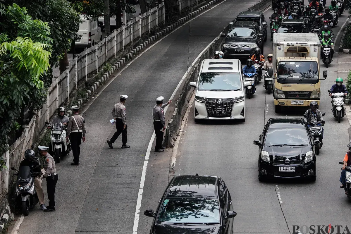 Sejumlah petugas kepolisian melakukan tilang kepada pengendara yang memasuki jalur Transjakarta di Jalan Sultan iskandar Muda, Jakarta Selatan, Selasa, 21 Oktober 2025. (Sumber: Poskota/Bilal Nugraha Ginanjar)
