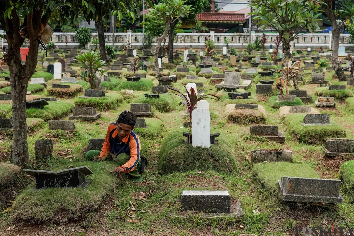 Petugas Suku Dinas Pertamanan dan Hutan Jakarta Selatan membersihkan salah satu makam di Tempat Pemakaman Umum (TPU) Grogol Selatan, Jakarta, Selasa, 21 Oktober 2025. (Sumber: Poskota/Bilal Nugraha Ginanjar)