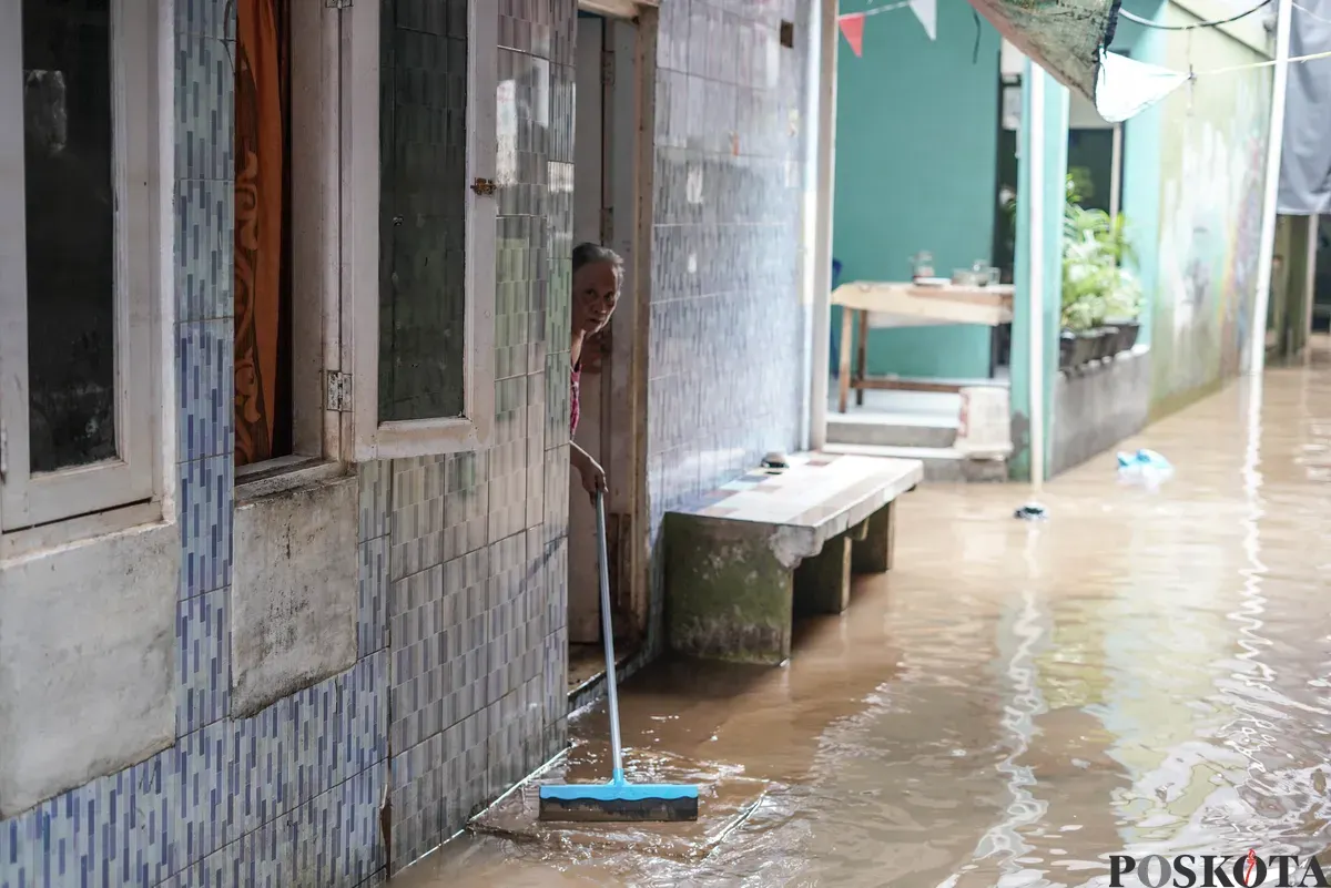 Warga berjalan melintasi banjir di Kebon Pala, Jatinegara, Jakarta Timur, Selasa, 28 Oktober 2025. (Sumber: Poskota/Bilal Nugraha Ginanjar)