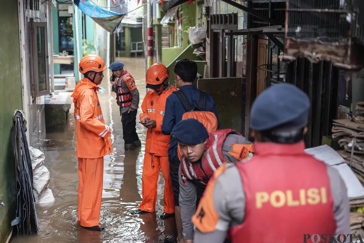 Warga berjalan melintasi banjir di Kebon Pala, Jatinegara, Jakarta Timur, Selasa, 28 Oktober 2025. (Sumber: Poskota/Bilal Nugraha Ginanjar)