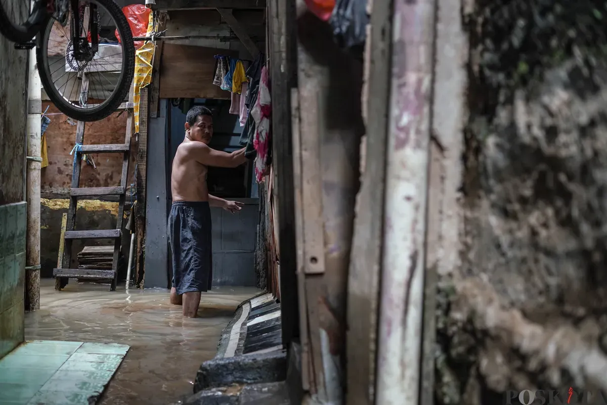 Warga berjalan melintasi banjir di Kebon Pala, Jatinegara, Jakarta Timur, Selasa, 28 Oktober 2025. (Sumber: Poskota/Bilal Nugraha Ginanjar)