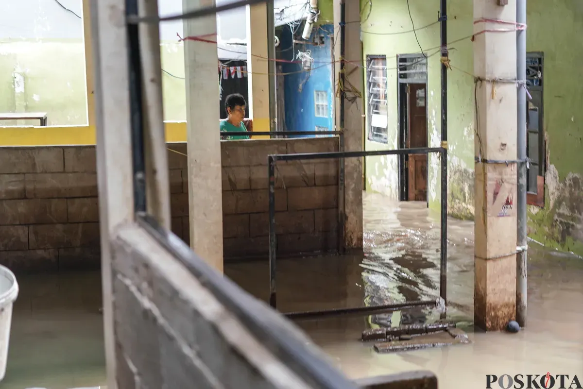 Warga berjalan melintasi banjir di Kebon Pala, Jatinegara, Jakarta Timur, Selasa, 28 Oktober 2025. (Sumber: Poskota/Bilal Nugraha Ginanjar)
