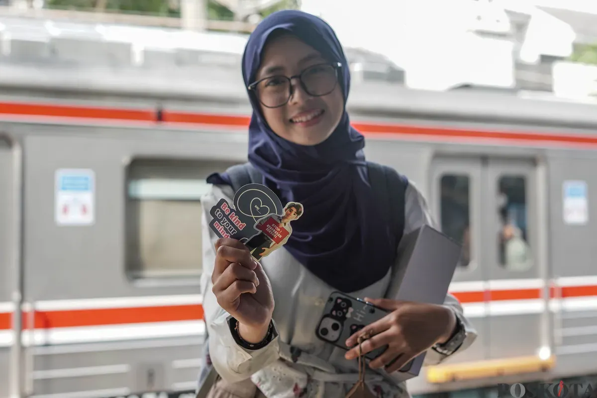 Penumoang Commuter Line menunjukan stiker Kampanye Anti Kekerasan Seksual di Stasiun Sudirman, Jakarta, Selasa, 28 Oktober 2025. (Sumber: Poskota/Bilal Nugraha Ginanjar)