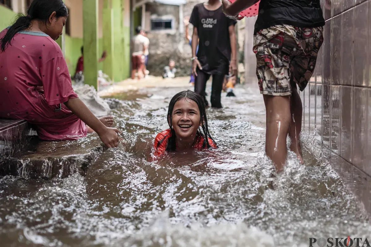 Anak-anak bermain air genangan banjir yang melanda kawasan RT 03, RW 06, Jati Padang, Pasar Minggu Jakarta Selatan, Jum'at, 31 Oktober 2025. (Sumber: Poskota/Bilal Nugraha Ginanjar)
