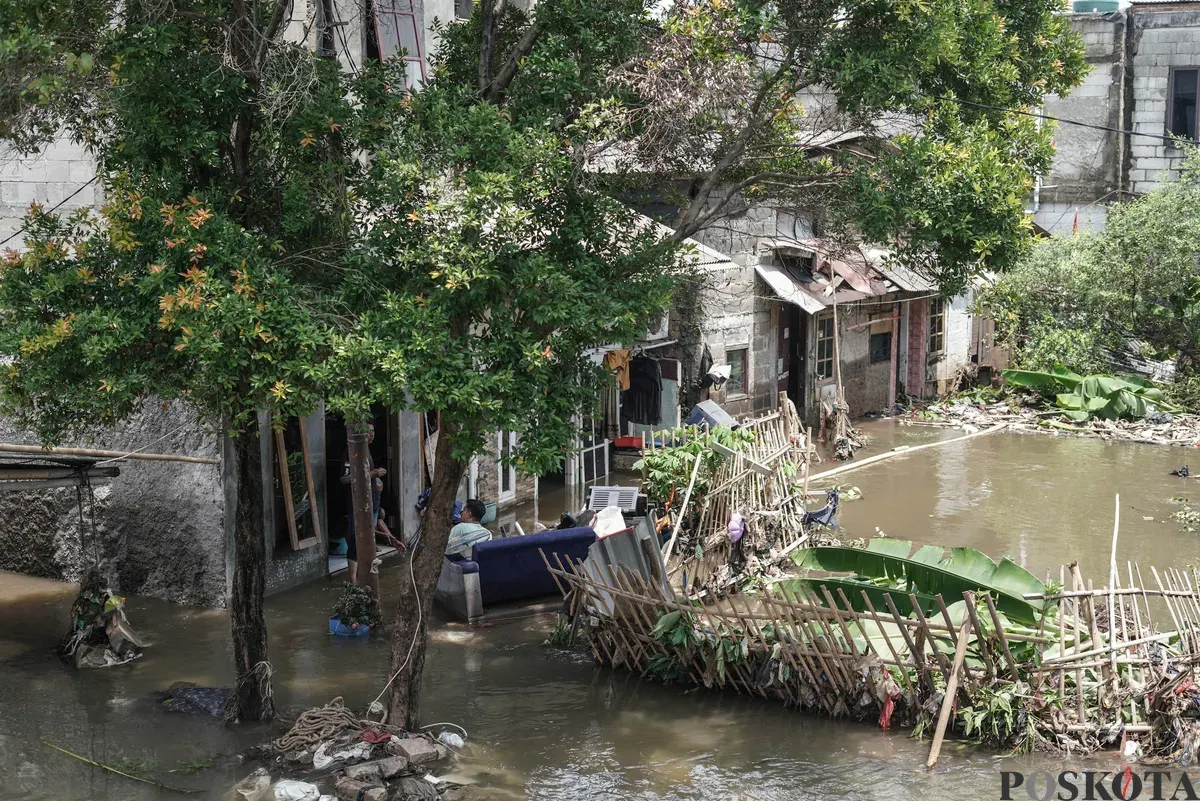 Warga berjalan menerobos banjir yang melanda kawasan RT 03, RW 06, Jati Padang, Pasar Minggu Jakarta Selatan, Jum'at, 31 Oktober 2025. (Sumber: Poskota/Bilal Nugraha Ginanjar)