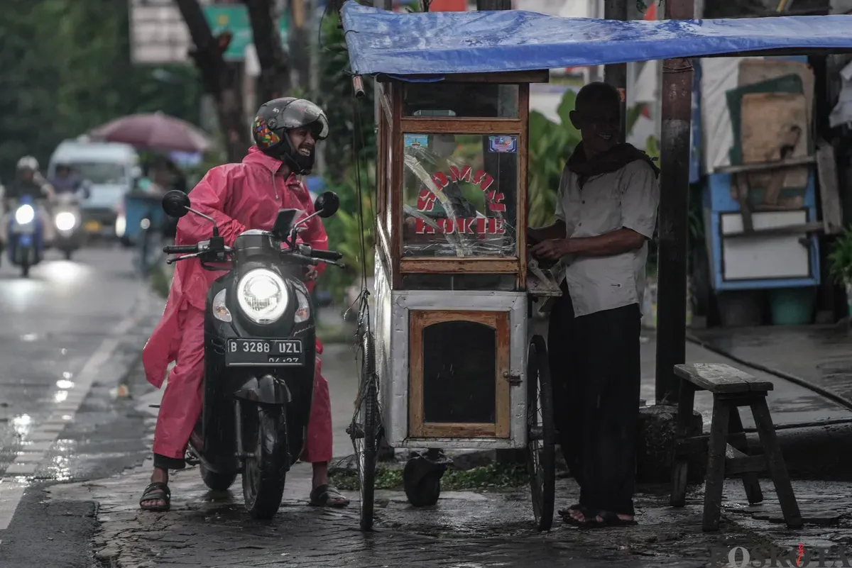 Pengendara sepeda motor menerobos hujan di Jalan Bang Pitung, Kebon Jeruk Jakarta Barat, Kamis, 30 Oktober 2025. (Sumber: Poskota/Bilal Nugraha Ginanjar)