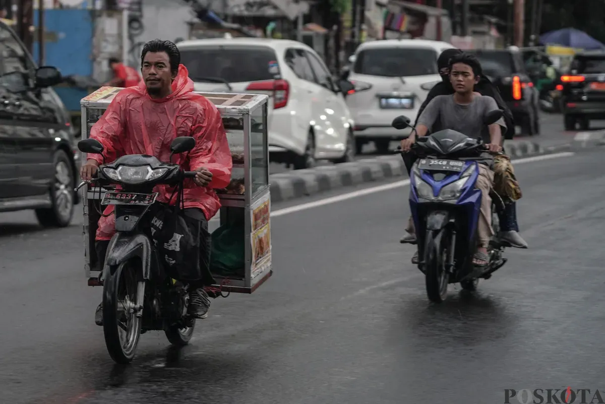Pengendara sepeda motor menerobos hujan di Jalan Bang Pitung, Kebon Jeruk Jakarta Barat, Kamis, 30 Oktober 2025. (Sumber: Poskota/Bilal Nugraha Ginanjar)