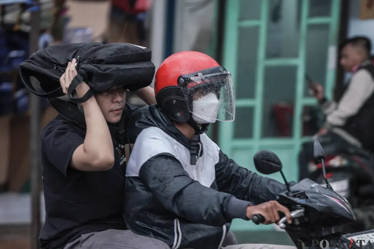 Pengendara sepeda motor menerobos hujan di Jalan Bang Pitung, Kebon Jeruk Jakarta Barat, Kamis, 30 Oktober 2025. (Sumber: Poskota/Bilal Nugraha Ginanjar)
