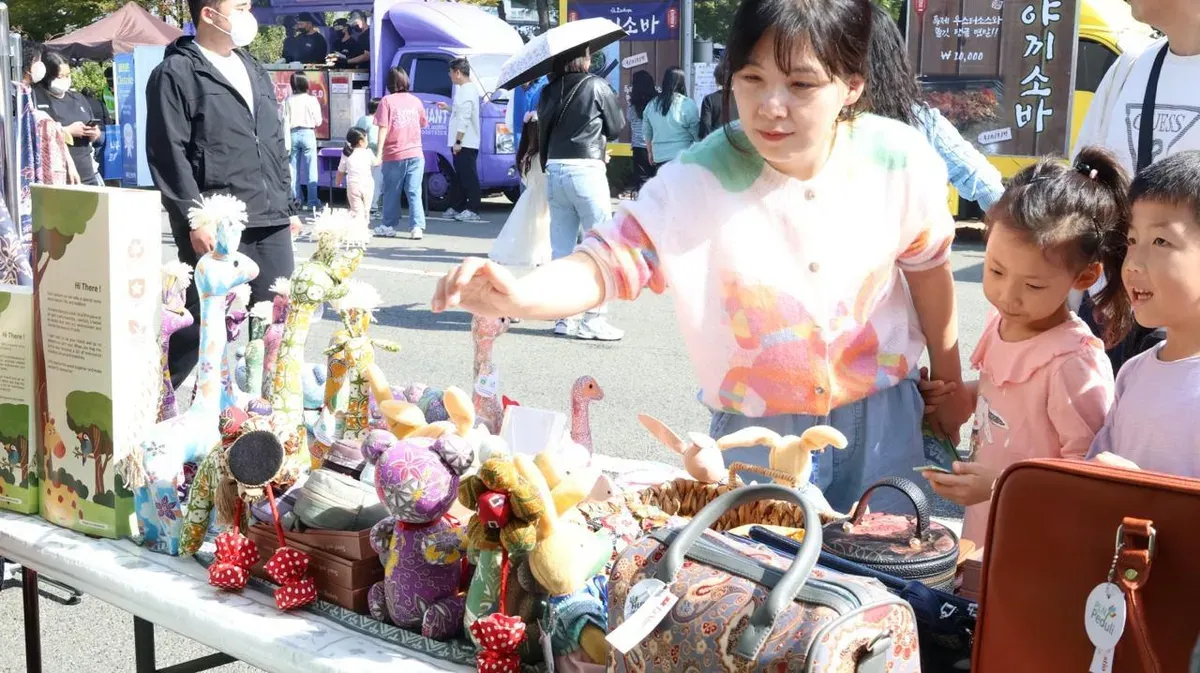 Pengunjung asal Korea Selatan antusias melihat dan memilih produk craft boneka batik karya UMKM binaan PLN UID Jakarta Raya di ajang Migran Arirang Multicultural Festival  (MAMF) 24 - 26 Oktober 2025 di Changwon, Korea Selatan. (Sumber: Istimewa)
