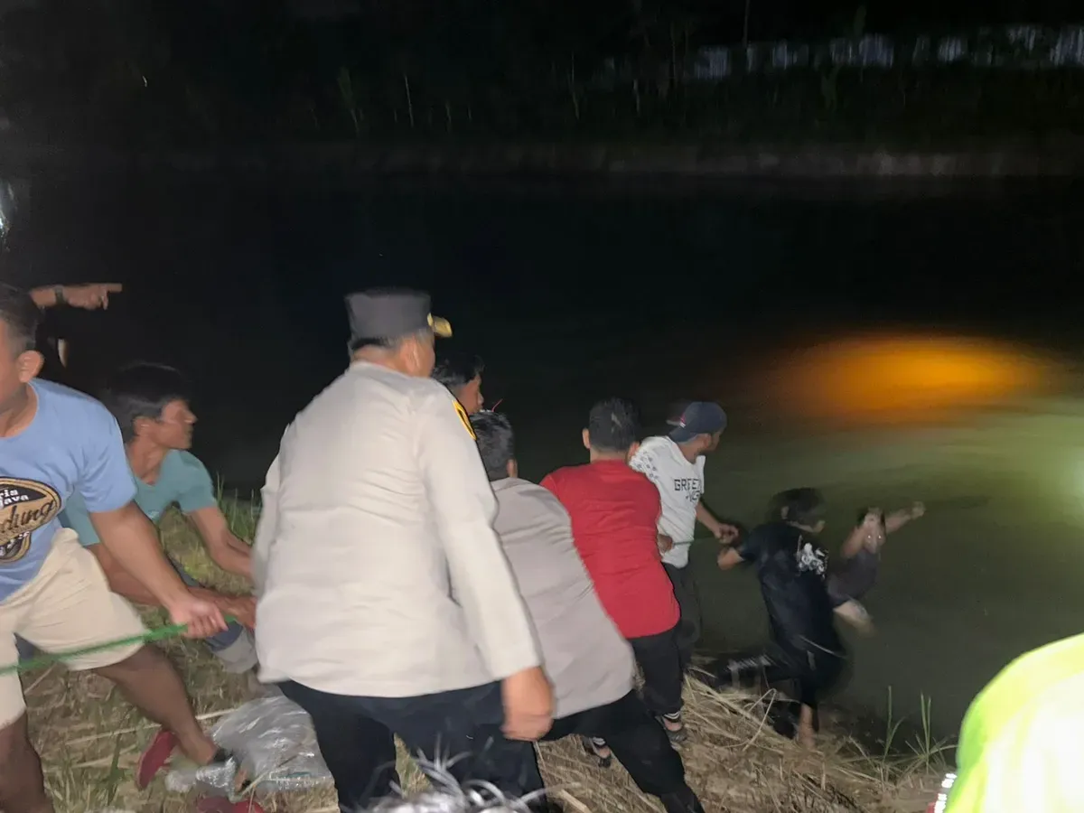 Petugas Polsek Kragilan dibantu masyarakat mengevakuasi kendaraan dari dalam sungai irigasi. (Sumber: Polres Serang)