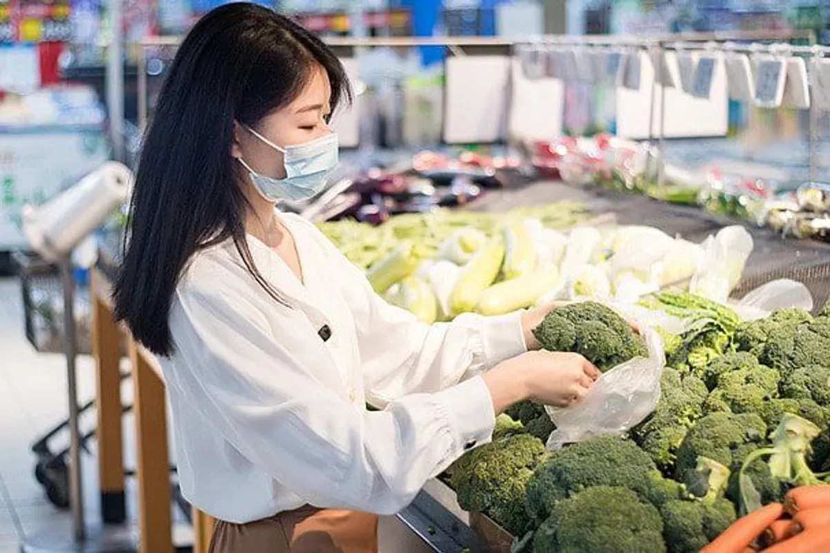 Seorang ibu tengah memilih sayuran di pasar tradisional dengan cermat. (Sumber: Pinterest)