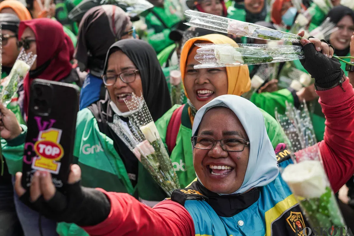 Sejumlah pengemudi ojek daring (ojol) membagikan bunga kepada petugas di kawasan Monumen Nasional, Jakarta, Selasa, 2 September 2025. (Sumber: Poskota/Bilal Nugraha Ginanjar)