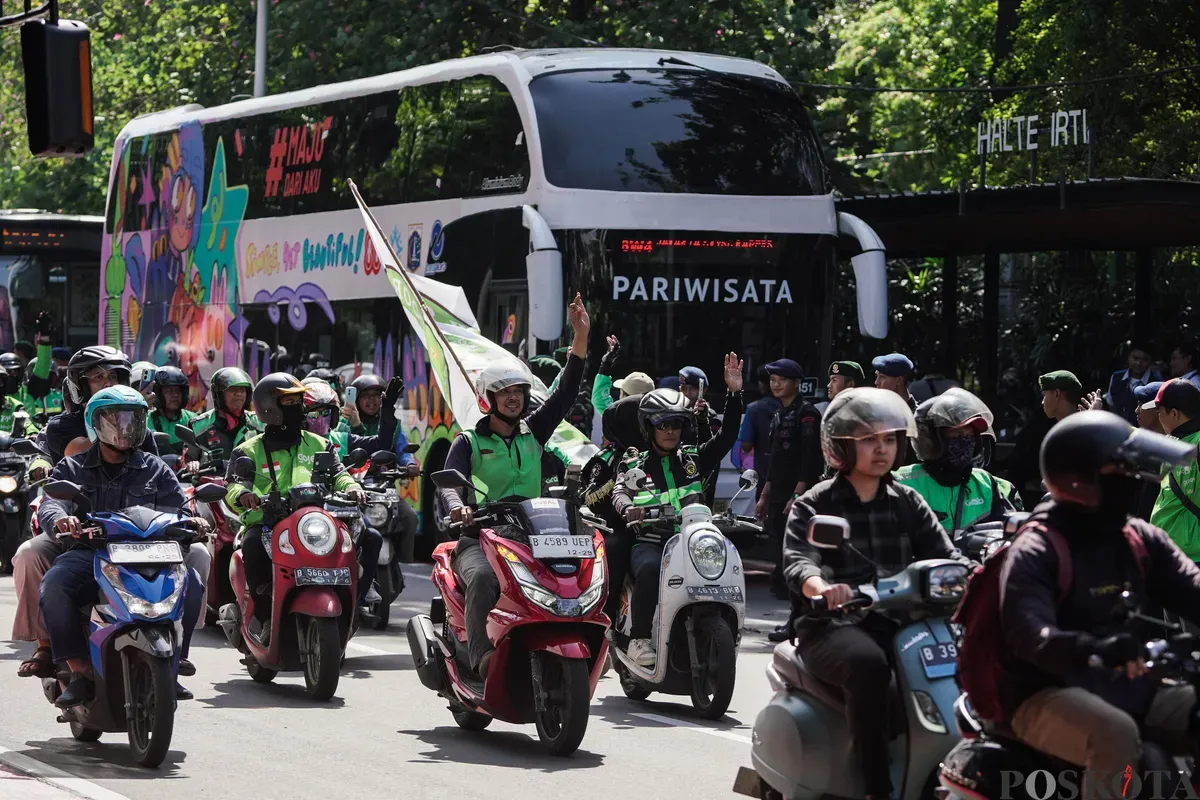 Sejumlah pengemudi ojek daring (ojol) membagikan bunga kepada petugas di kawasan Monumen Nasional, Jakarta, Selasa, 2 September 2025. (Sumber: Poskota/Bilal Nugraha Ginanjar)