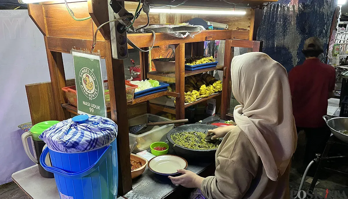 Hanifah, pedagang ayam penyet sambel ijo di kawasan Palmerah, Jakarta Barat, saat sedang melayani pembeli, Rabu, 10 September 2025. (Sumber: POSKOTA | Foto: Pandi Ramedhan)