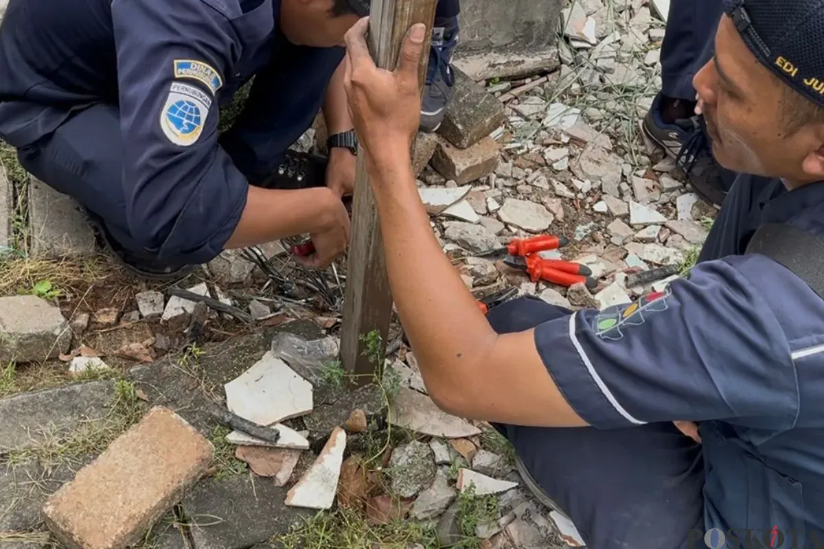 Petugas merapikan kabel traffic lifht di Jalan Green Garden, Kedoya Utara, Kebon Jeruk, Jakarta Barat, yang dicuri orang tidak dikenal, Kamis, 11 September 2025. (Sumber: Poskota/Pandi Ramedhan)
