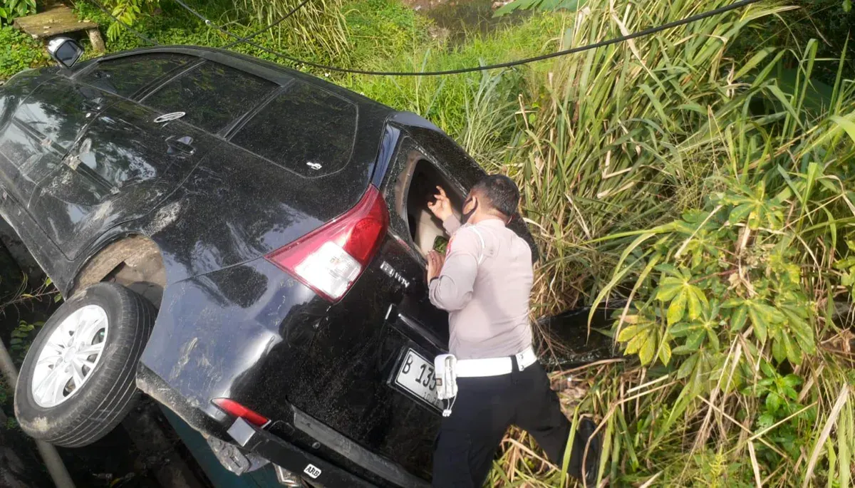 Kanit Lantas Polsek Bojong Sari, Iptu Suwardi saat melakukan olah TKP mobil masuk ke dalam selokan di Jalan Raya Parung-Ciputat, Kota Depok. (Sumber: Dok Polsek Bojongsari)