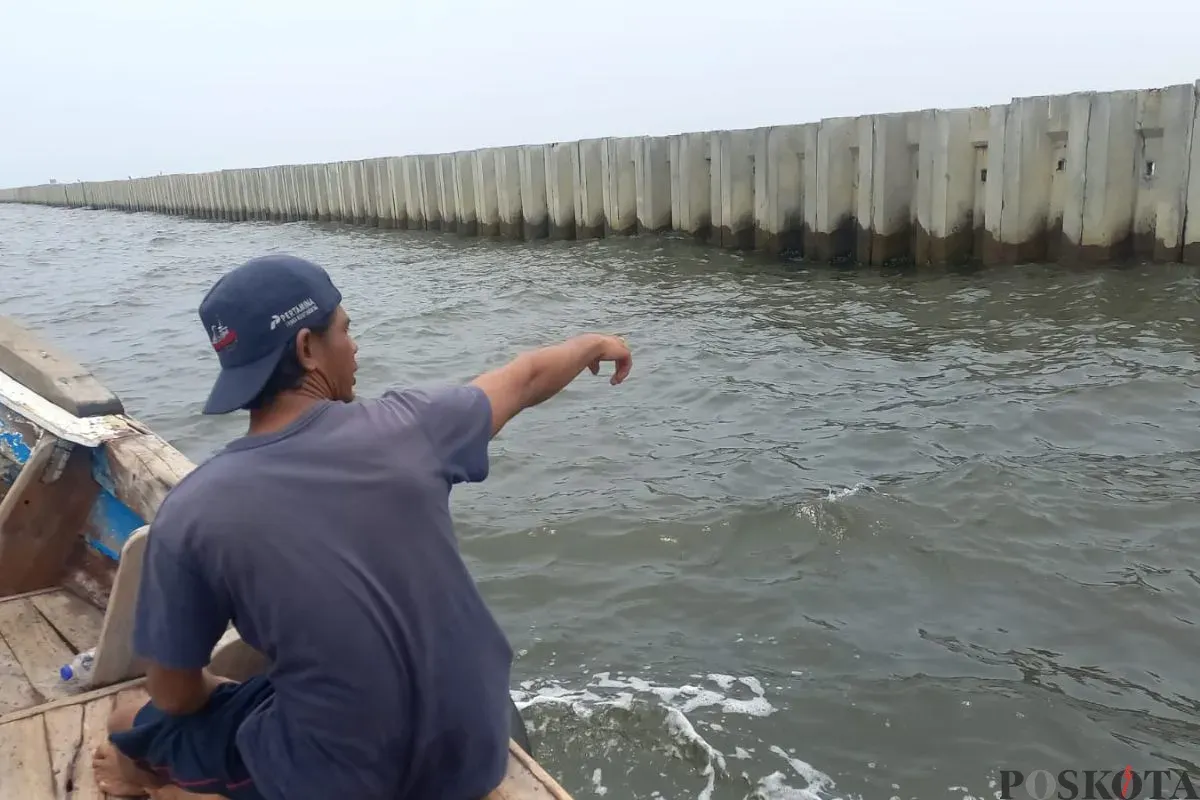 Salah seorang nelayan menunjukkan Tanggul Beton di perairan Cilincing, Jakarta Utara, Kamis, 11 September 2025. (Sumber: Poskota/Muhammad Tegar Jihad)