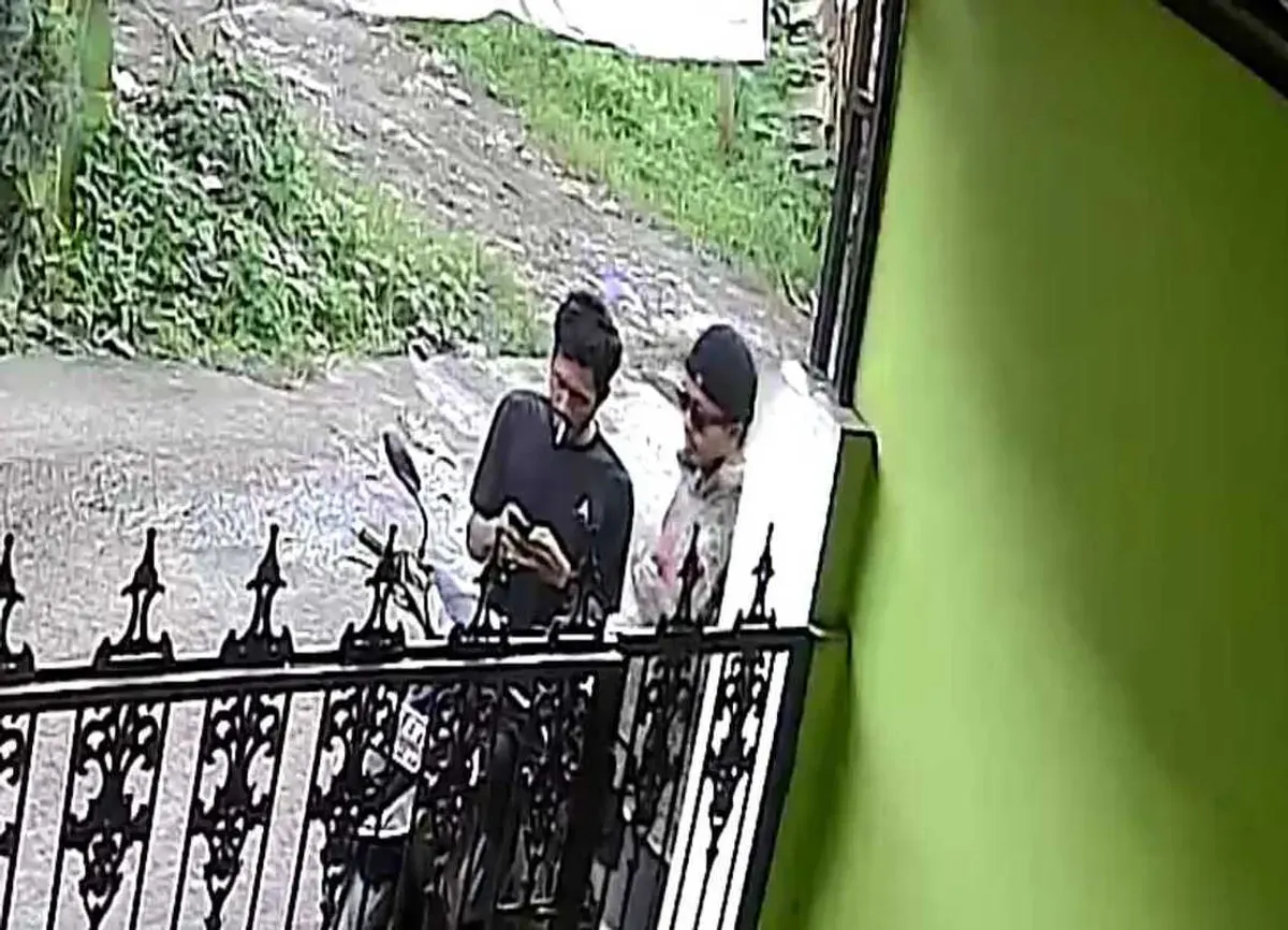 Tangkapan layar kamera CCTV warga memperlihatkan dua orang mencurigakan bertransaksi narkoba di depan rumah. (Sumber: Istimewa)