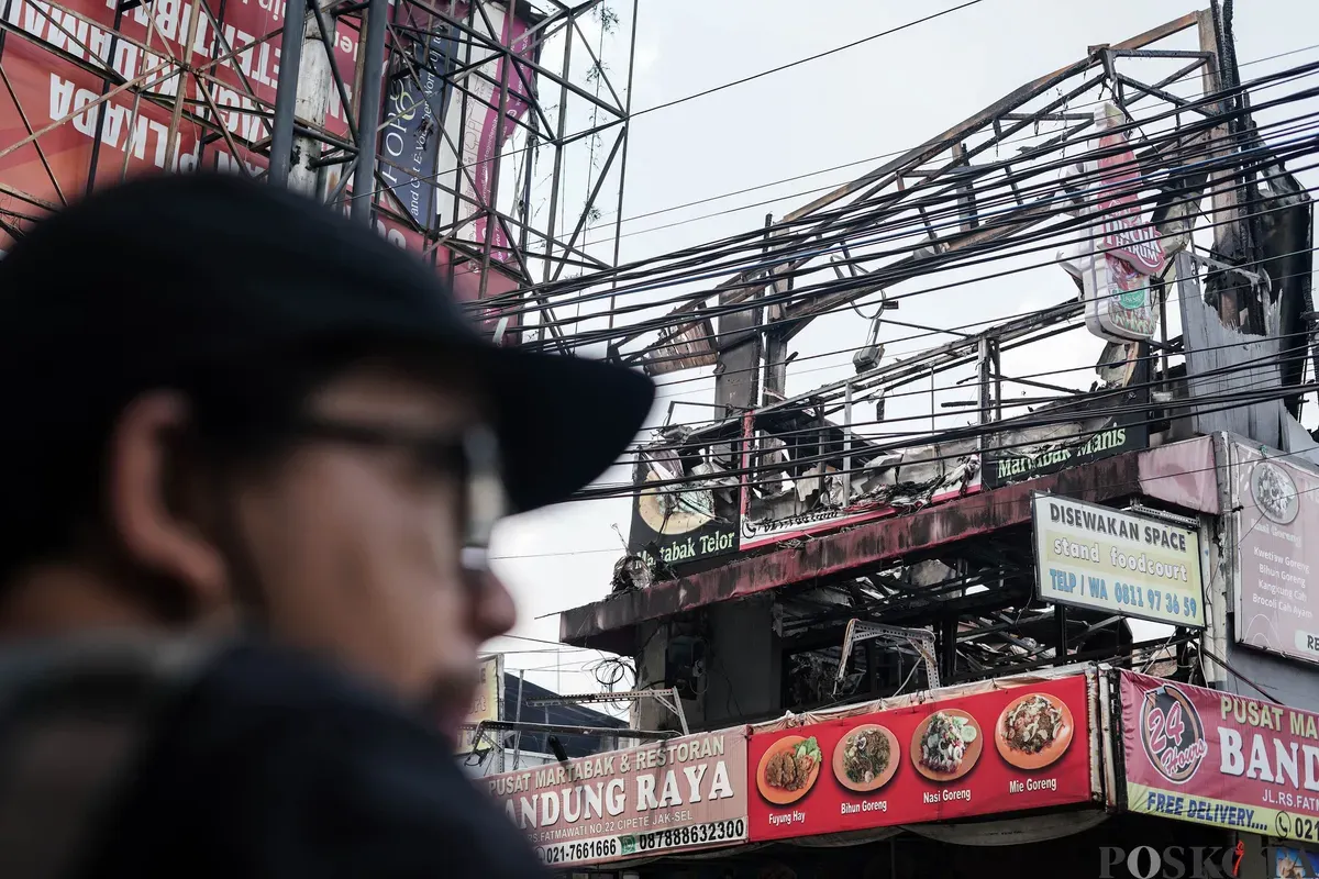 Warga mengamati area pusat jajanan serba ada (Pujasera) pascakebakaran di Jalan RS Fatmawati Raya, Gandaria Selatan, Jakarta, Senin, 8 September 2025. (Sumber: Poskota/Bilal Nugraha Ginanjar)