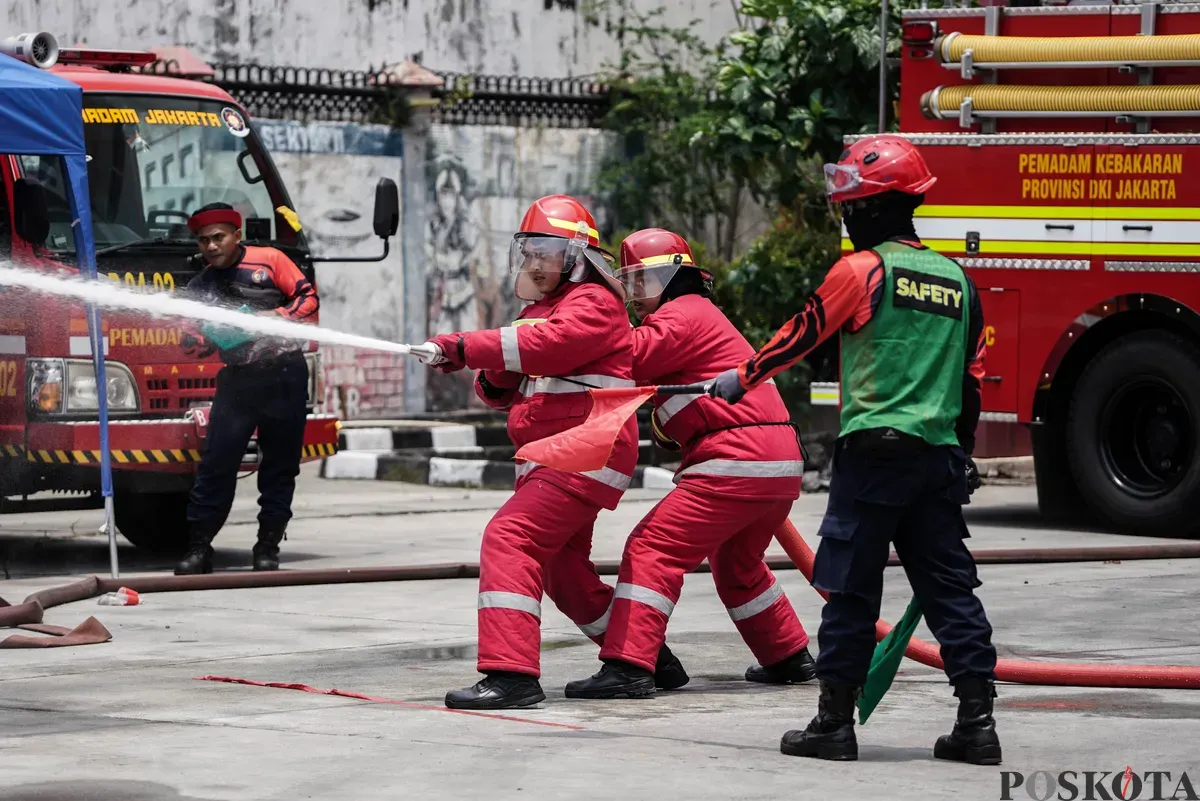Relawan pemadam kebakaran berupaya memadamkan api menggunakan Alat Pemadam Api Ringan (APAR) pada Jakarta Fire Safety Challenge 2025 di Kantor Dinas Penanggulangan Kebakaran dan Penyelamatan (Gulkarmat) DKI Jakarta, Selasa 16 September 2025. (Sumber: Poskota/Bilal Nugraha Ginanjar)