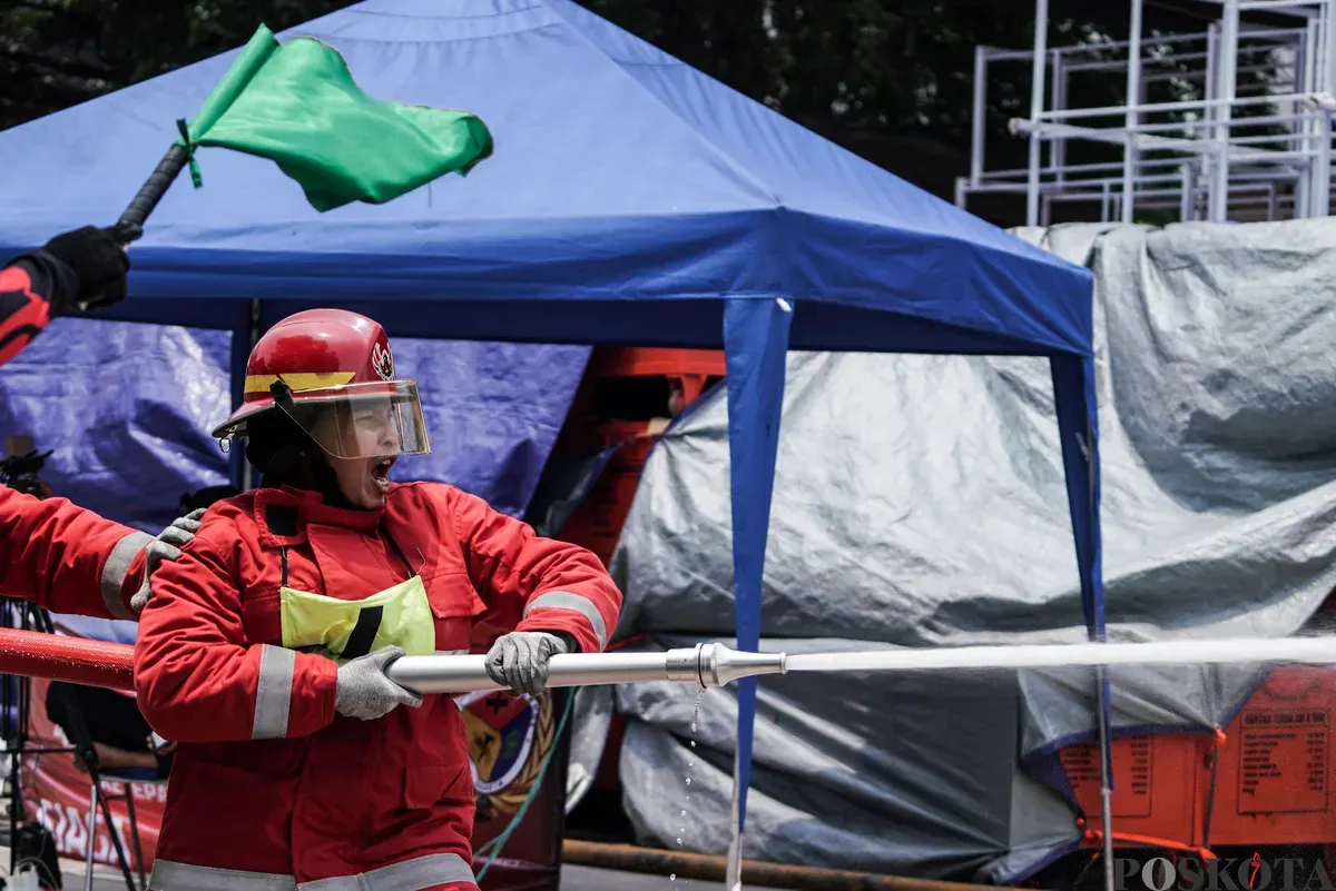 Relawan pemadam kebakaran berupaya memadamkan api menggunakan Alat Pemadam Api Ringan (APAR) pada Jakarta Fire Safety Challenge 2025 di Kantor Dinas Penanggulangan Kebakaran dan Penyelamatan (Gulkarmat) DKI Jakarta, Selasa 16 September 2025. (Sumber: Poskota/Bilal Nugraha Ginanjar)