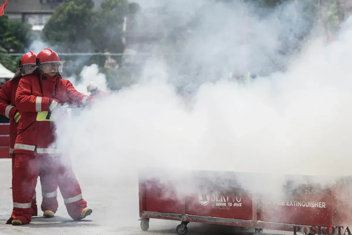 Relawan pemadam kebakaran berupaya memadamkan api menggunakan Alat Pemadam Api Ringan (APAR) pada Jakarta Fire Safety Challenge 2025 di Kantor Dinas Penanggulangan Kebakaran dan Penyelamatan (Gulkarmat) DKI Jakarta, Selasa 16 September 2025. (Sumber: Poskota/Bilal Nugraha Ginanjar)