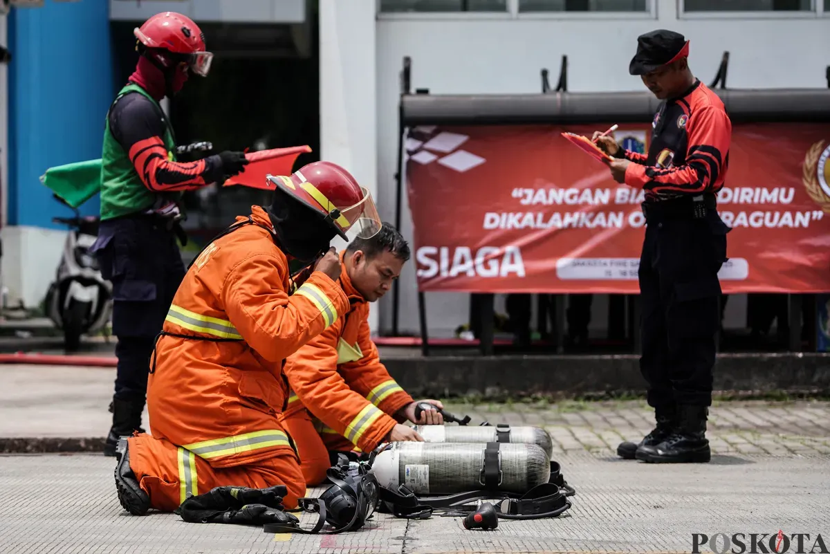 Relawan pemadam kebakaran berupaya memadamkan api menggunakan Alat Pemadam Api Ringan (APAR) pada Jakarta Fire Safety Challenge 2025 di Kantor Dinas Penanggulangan Kebakaran dan Penyelamatan (Gulkarmat) DKI Jakarta, Selasa 16 September 2025. (Sumber: Poskota/Bilal Nugraha Ginanjar)