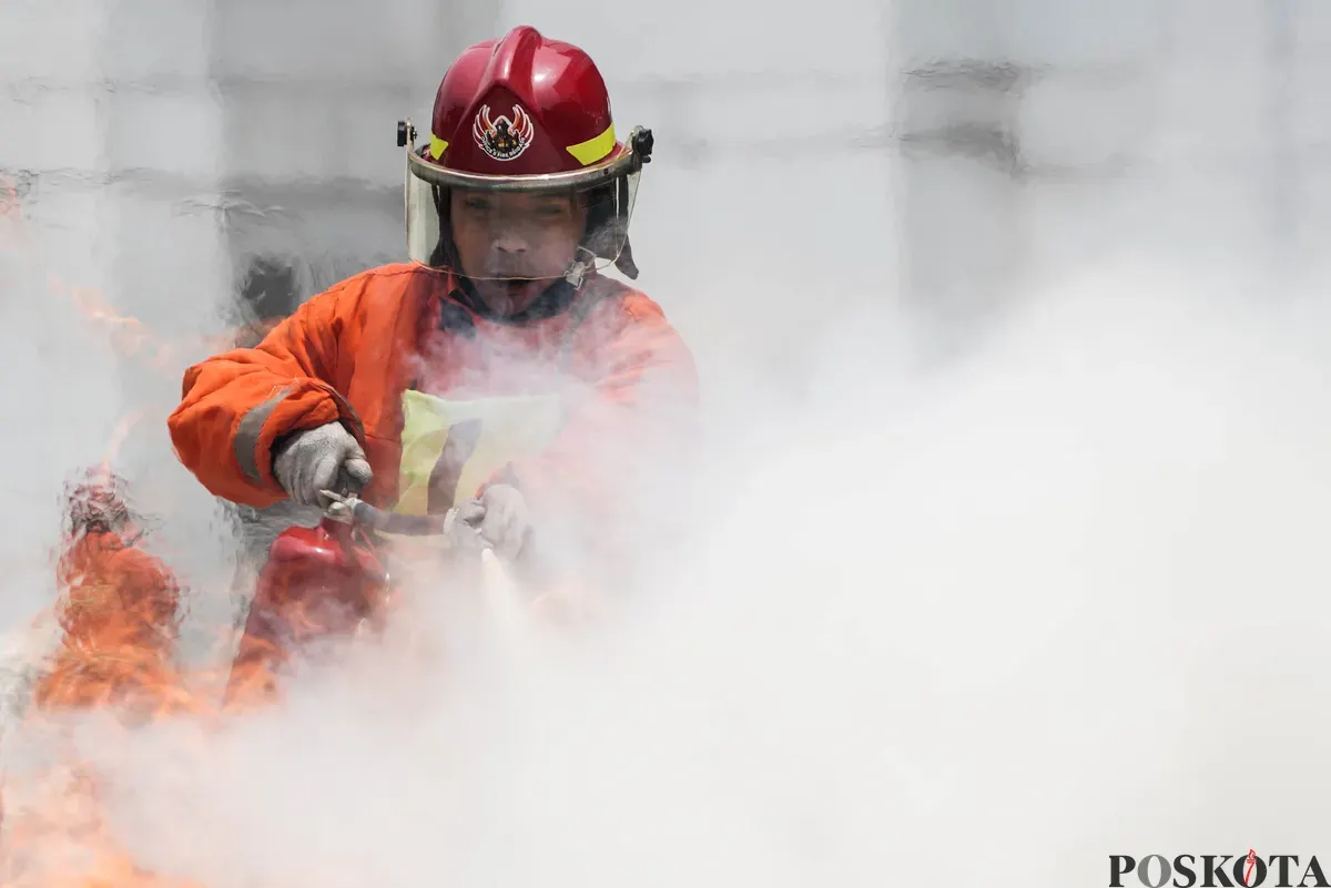 Relawan pemadam kebakaran berupaya memadamkan api menggunakan Alat Pemadam Api Ringan (APAR) pada Jakarta Fire Safety Challenge 2025 di Kantor Dinas Penanggulangan Kebakaran dan Penyelamatan (Gulkarmat) DKI Jakarta, Selasa 16 September 2025. (Sumber: Poskota/Bilal Nugraha Ginanjar)