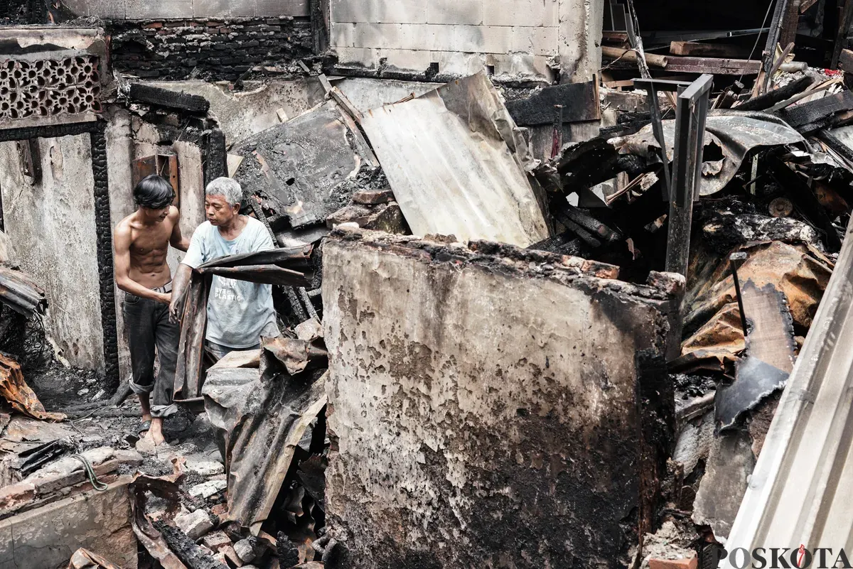 Warga membawa barang-barang yang masih bisa diselamatkan dari kebakaran di Senen, Jakarta Pusat, Senin, 15 September 2025. (Sumber: Poskota/Bilal Nugraha Ginanjar)