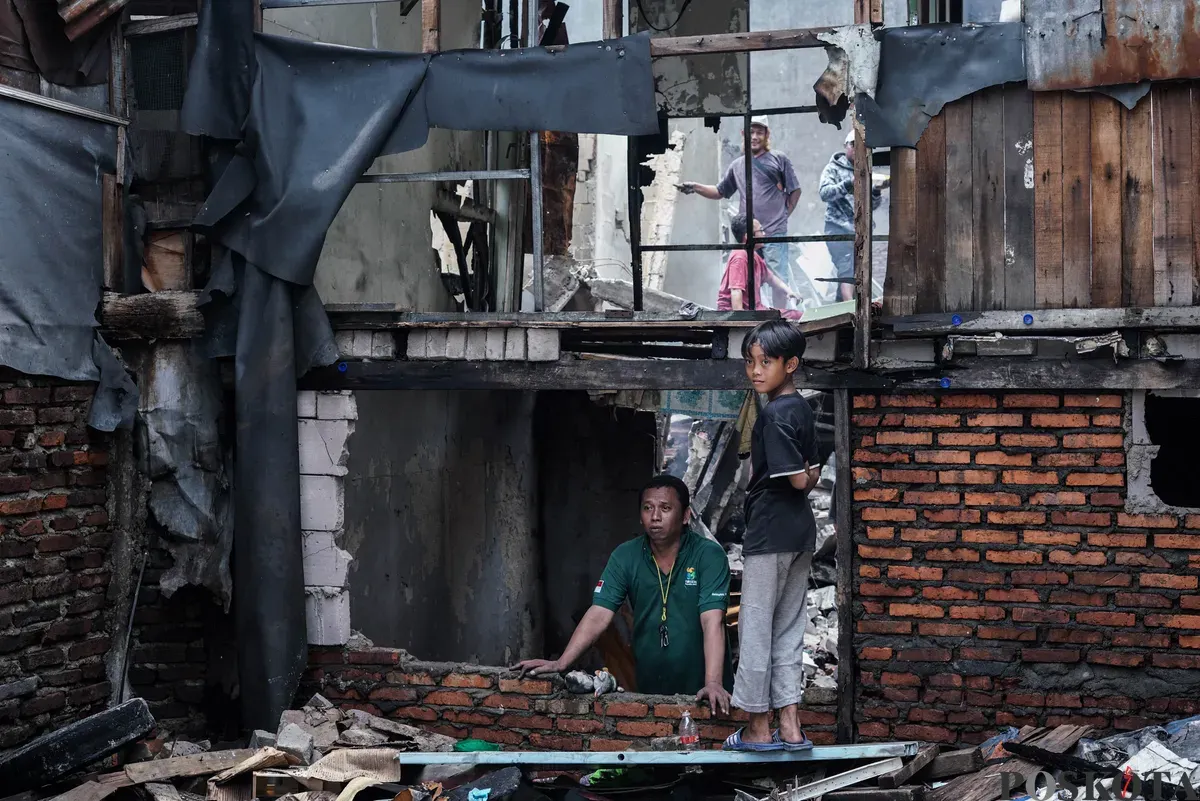 Warga membawa barang-barang yang masih bisa diselamatkan dari kebakaran di Senen, Jakarta Pusat, Senin, 15 September 2025. (Sumber: Poskota/Bilal Nugraha Ginanjar)