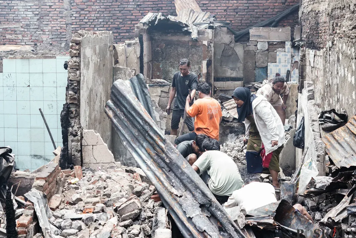 Warga membawa barang-barang yang masih bisa diselamatkan dari kebakaran di Senen, Jakarta Pusat, Senin, 15 September 2025. (Sumber: Poskota/Bilal Nugraha Ginanjar)