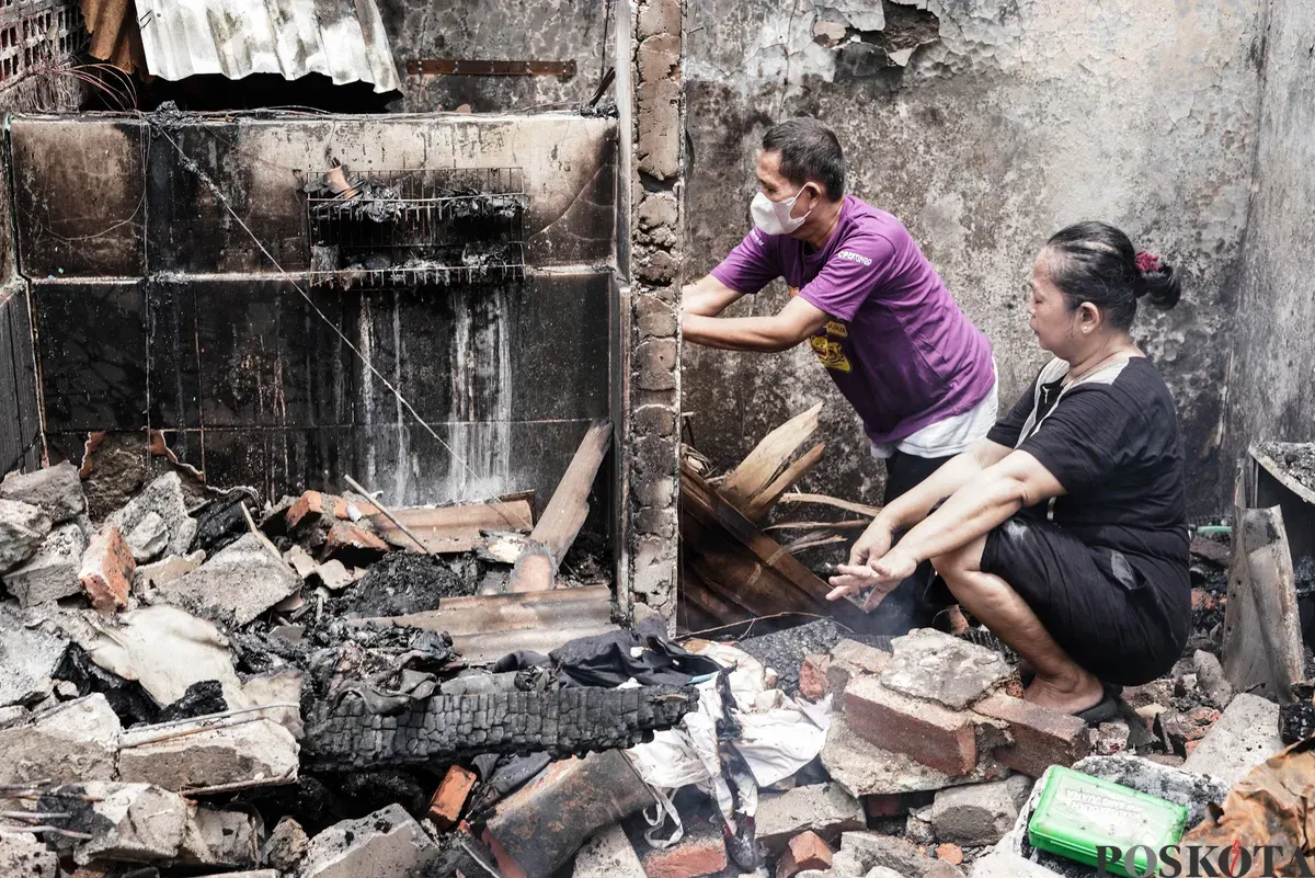Warga membawa barang-barang yang masih bisa diselamatkan dari kebakaran di Senen, Jakarta Pusat, Senin, 15 September 2025. (Sumber: Poskota/Bilal Nugraha Ginanjar)